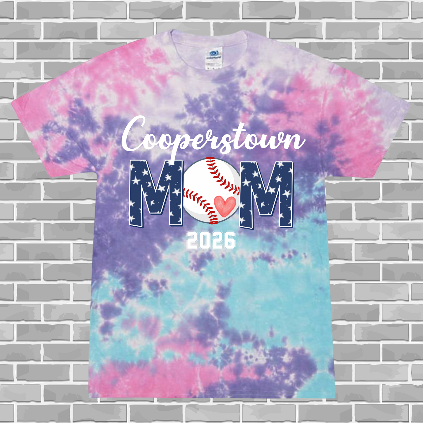 Tie-dye t-shirt with 'Cooperstown Mom 2026' text on a brick wall background